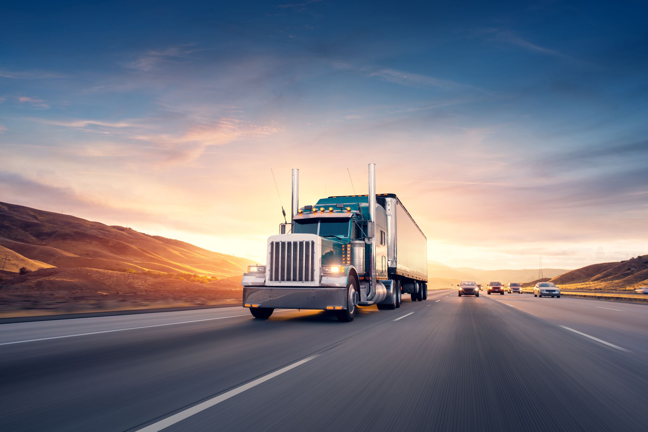 Tractor-trailer on highway at dusk.